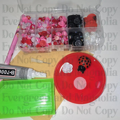 Rhinestone kit with wax pencil, glue-acrylic lid, tray, sandpaper, and charms