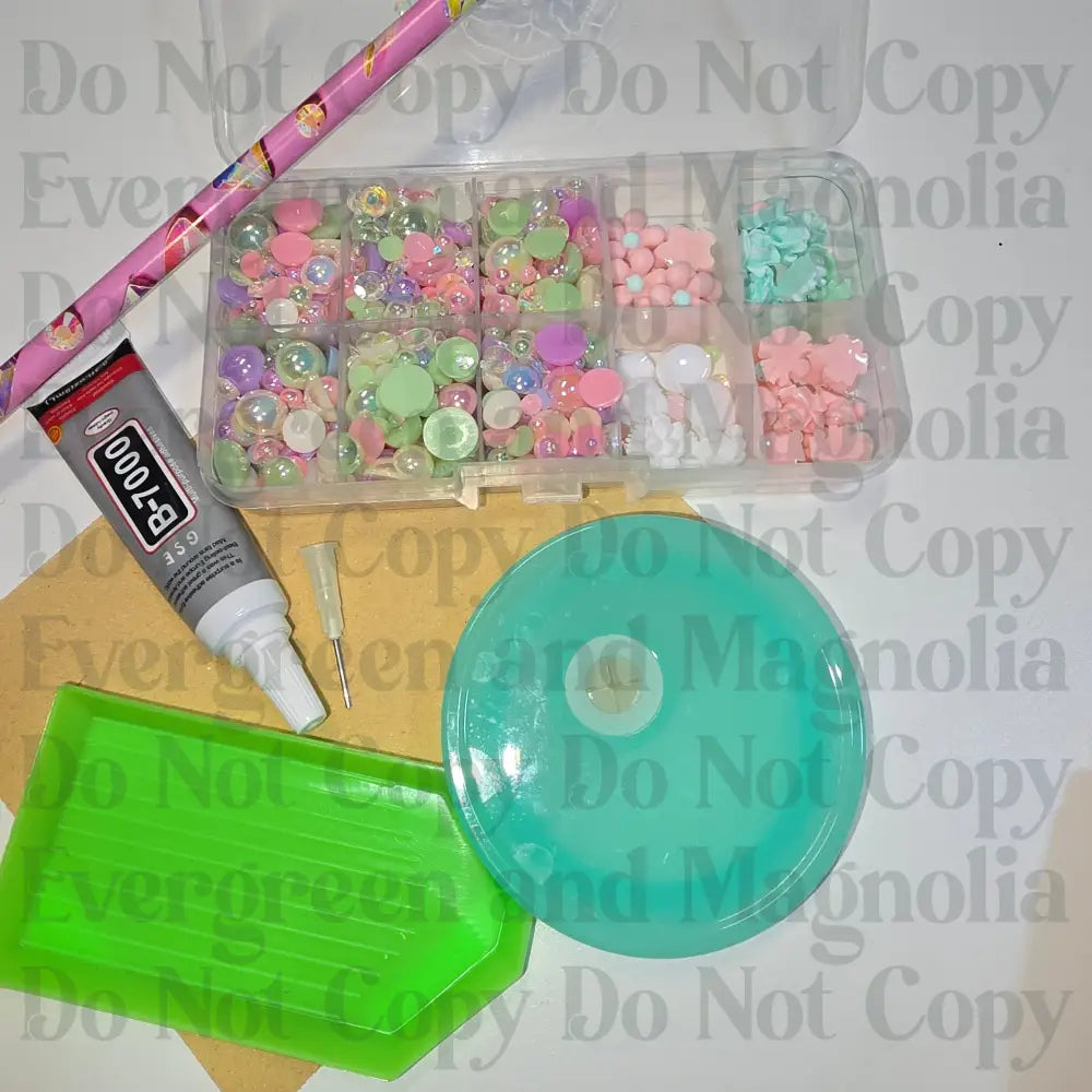 Rhinestone kit with wax pencil, glue-acrylic lid, tray, sandpaper, and charms