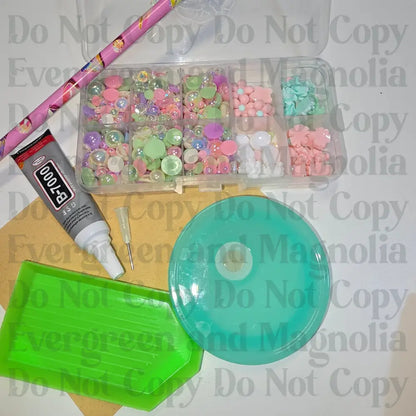 Rhinestone kit with wax pencil, glue-acrylic lid, tray, sandpaper, and charms